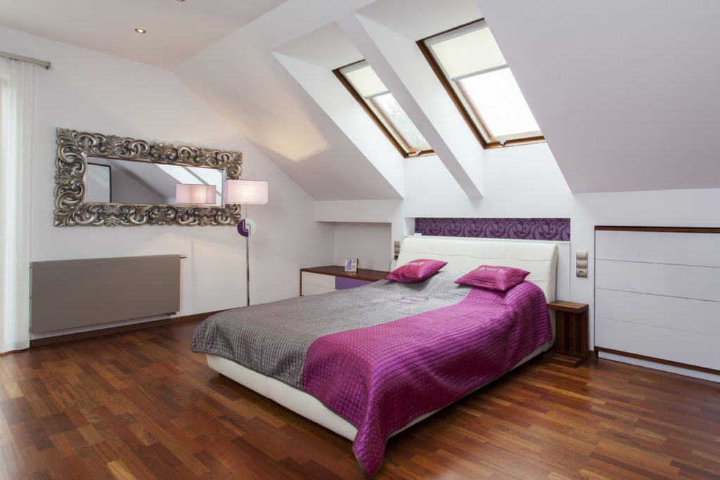 Мансардная спальня с розовыми элементами и коричневым полом