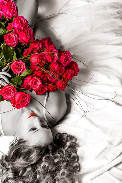 Женщина с большой букет из красных роз Лицензионные Стоковые Изображения