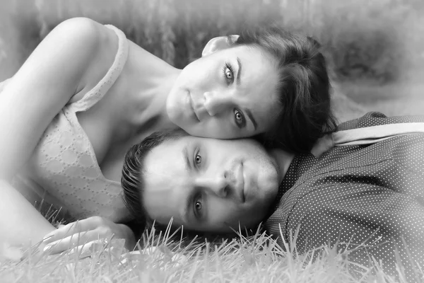 Черный и белый вариант молодая пара, лежа на траве wi Лицензионные Стоковые Изображения