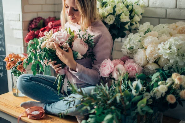 Портрет молодой женщины флорист с красных тюльпанов, глядя на камеру Стоковое Фото