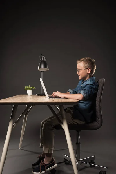 Side View Happy Schoolboy Using Laptop Table Lamp Potted Plant — стоковое фото
