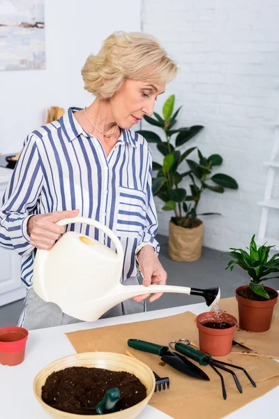 Beautiful Senior Woman Watering Soil Watering Can Home — стоковое фото