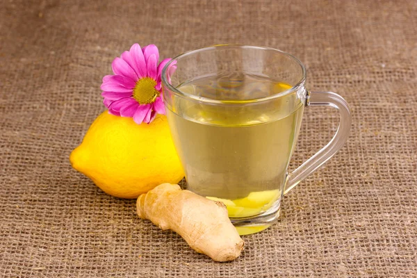 Здоровый имбирный чай с лимоном и цветок на вретище — стоковое фото